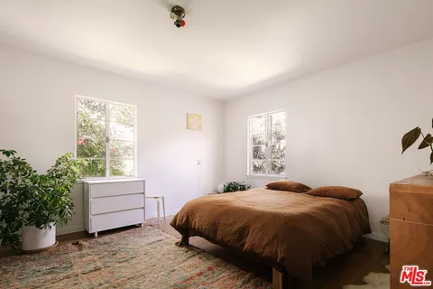a bed sitting in a bedroom next to a window