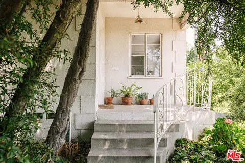 a living room with furniture potted plant and a large window
