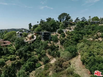 an aerial view of residential house with outdoor space and trees all around
