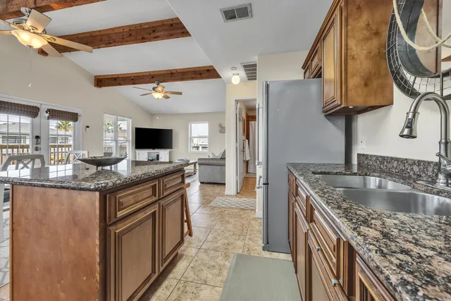 a kitchen with granite countertop a sink and a stove