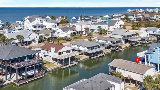 an aerial view of house with yard and ocean view