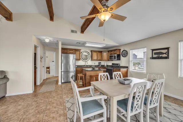 a view of a dining room with furniture and a chandelier fan