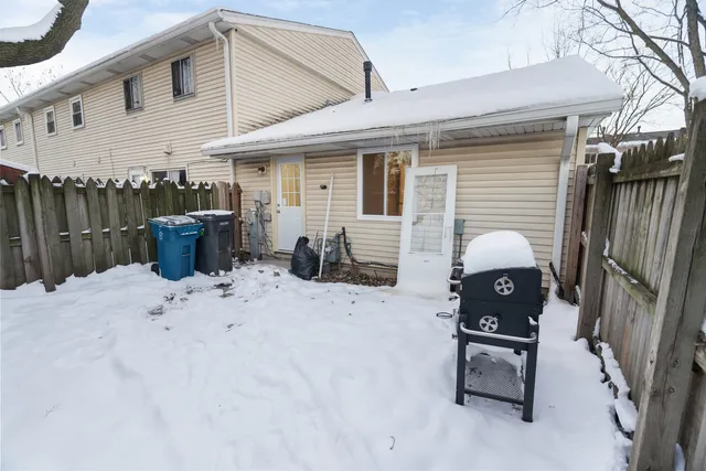 a view of a patio with wooden fence and a ceiling fan