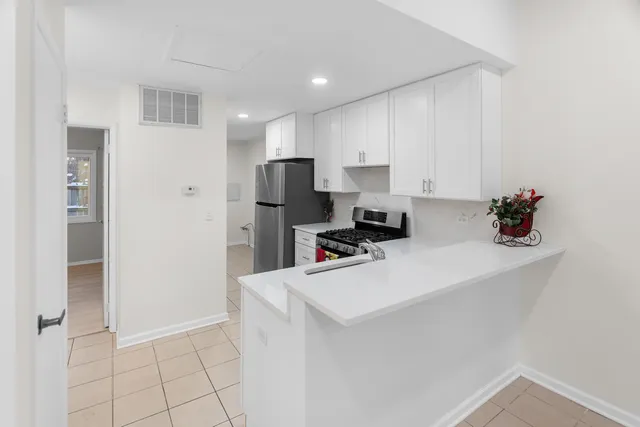 a room with a refrigerator a stove and cabinets