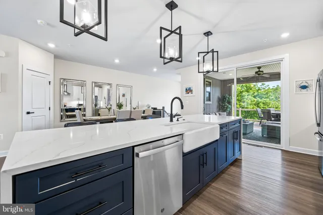 a kitchen with stainless steel appliances kitchen island granite countertop a sink stove and wooden floor