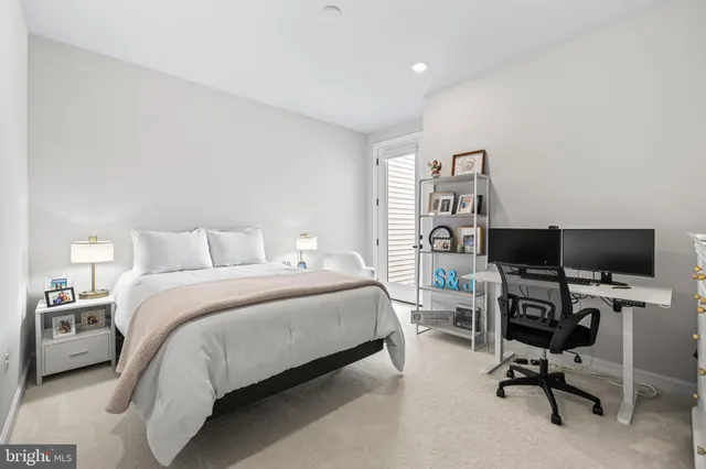 a bedroom with a bed a flat screen tv and chairs