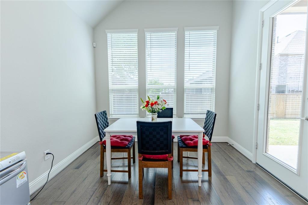 3920 Bentgrass Road Plano, TX 75023 - Photo 18 of 30 a view of a dining room with furniture and wooden floor