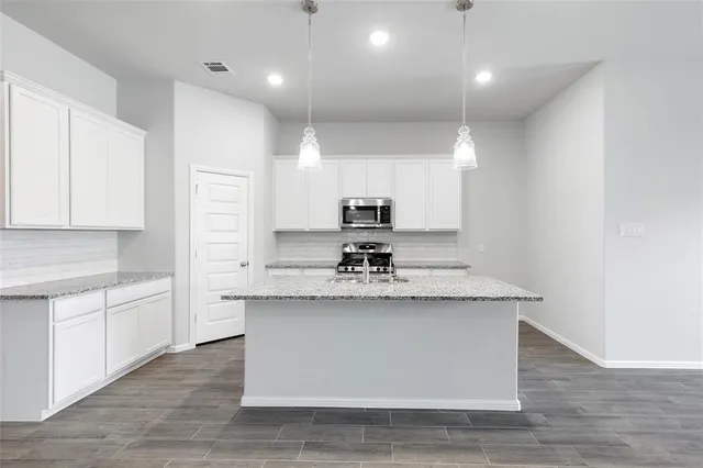 a view of living room with granite countertop couches with wooden floor