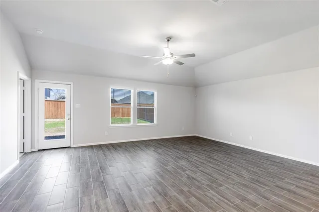 a view of an empty room with kitchen view and kitchen view