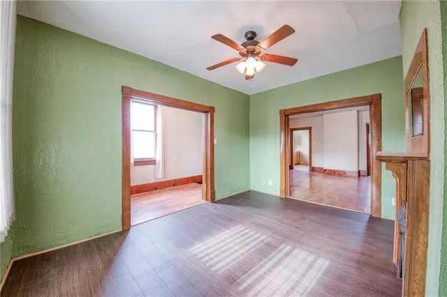 a view of an empty room with window and wooden floor