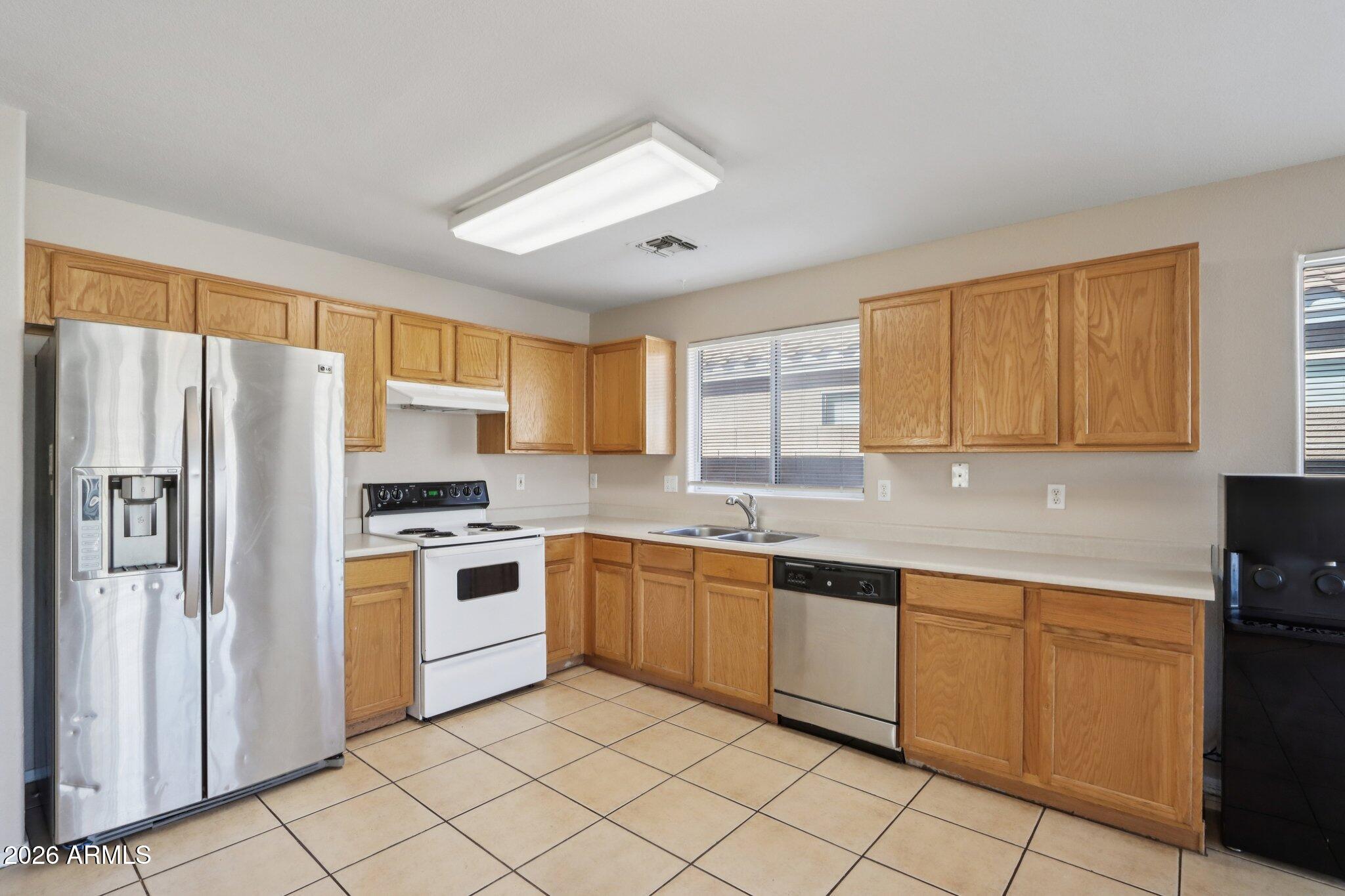 3326 West Shumway Farm Road Phoenix, AZ 85041 - Photo 12 of 30 a kitchen with stainless steel appliances granite countertop refrigerator sink and cabinets