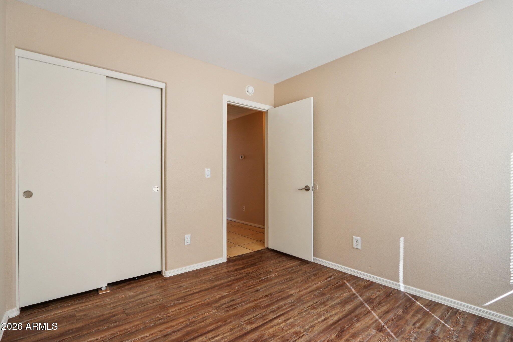 3326 West Shumway Farm Road Phoenix, AZ 85041 - Photo 15 of 30 a view of an empty room with wooden floor