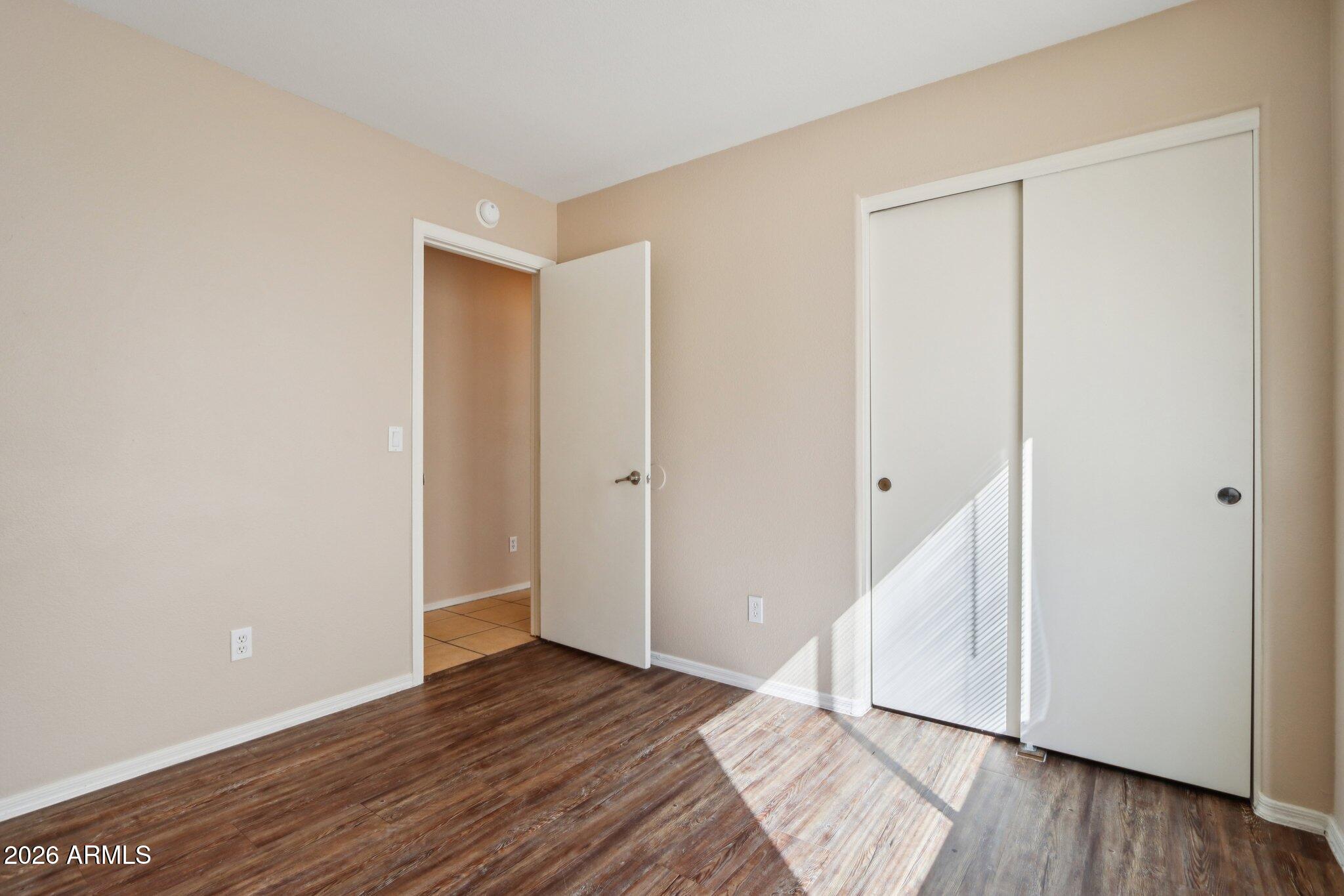 3326 West Shumway Farm Road Phoenix, AZ 85041 - Photo 18 of 30 an empty room with wooden floor and entryway