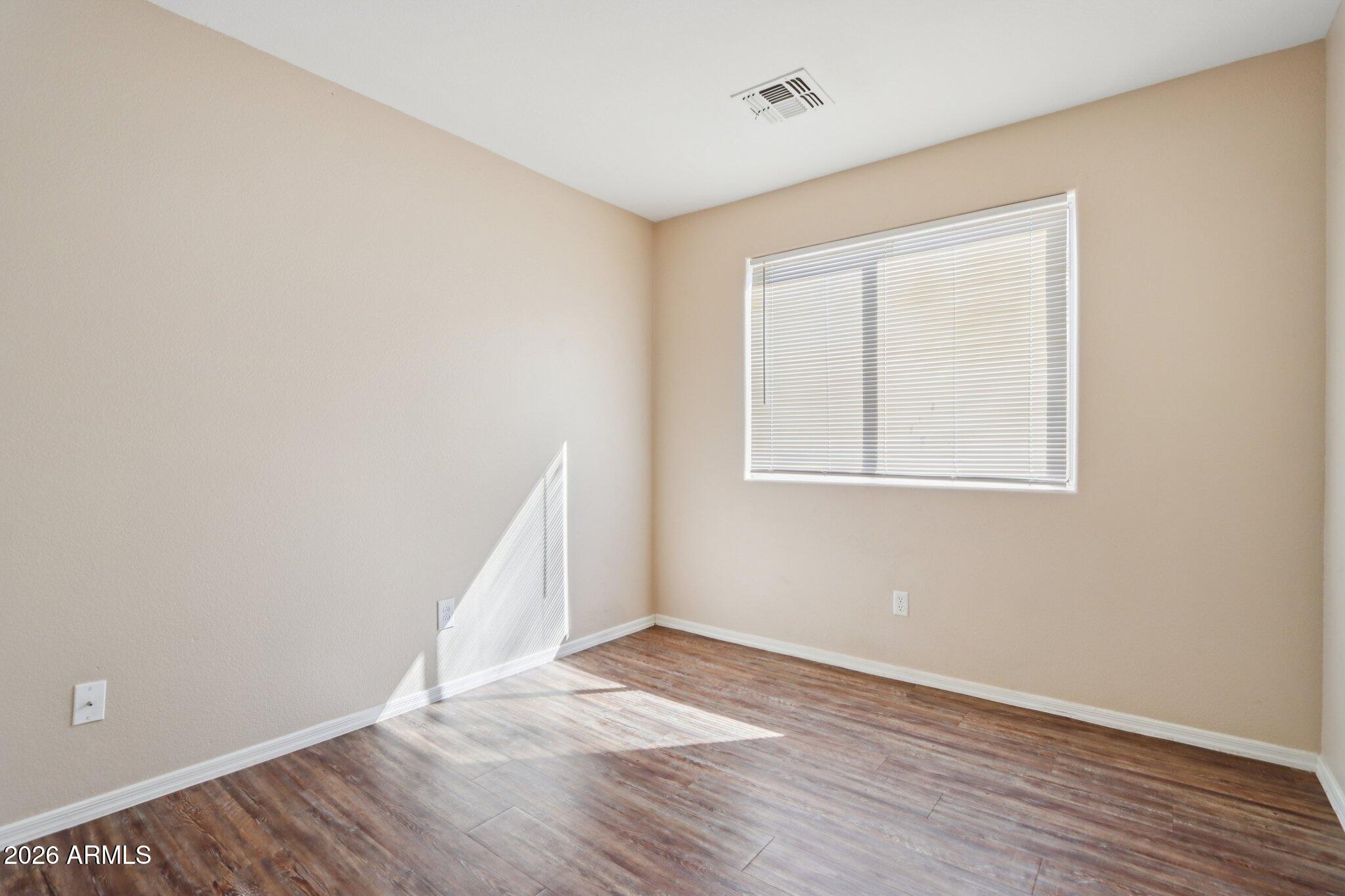 3326 West Shumway Farm Road Phoenix, AZ 85041 - Photo 19 of 30 an empty room with wooden floor and windows