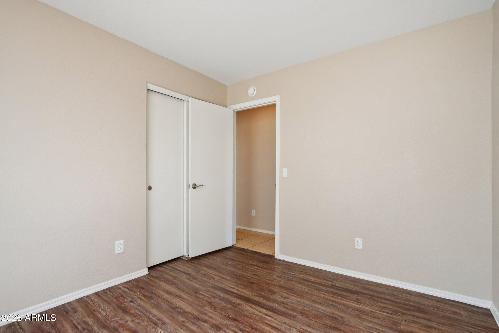 3326 West Shumway Farm Road Phoenix, AZ 85041 - Photo 20 of 30 a view of an empty room with wooden floor