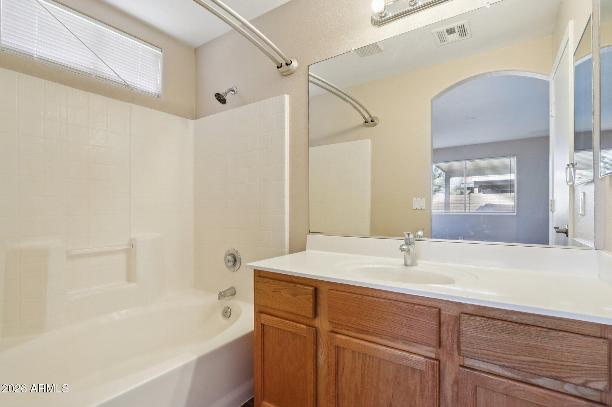 3326 West Shumway Farm Road Phoenix, AZ 85041 - Photo 21 of 30 a bathroom with a tub sink and mirror