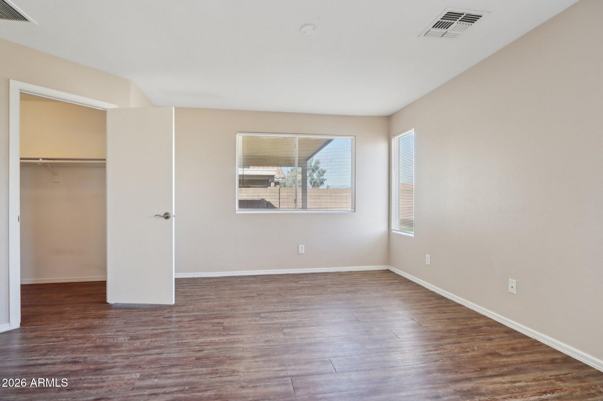 3326 West Shumway Farm Road Phoenix, AZ 85041 - Photo 22 of 30 a view of an empty room with wooden floor and a window
