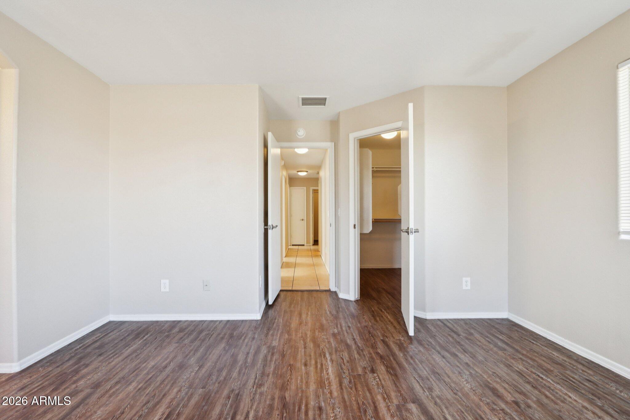 3326 West Shumway Farm Road Phoenix, AZ 85041 - Photo 23 of 30 a view of a room with wooden floor and white walls