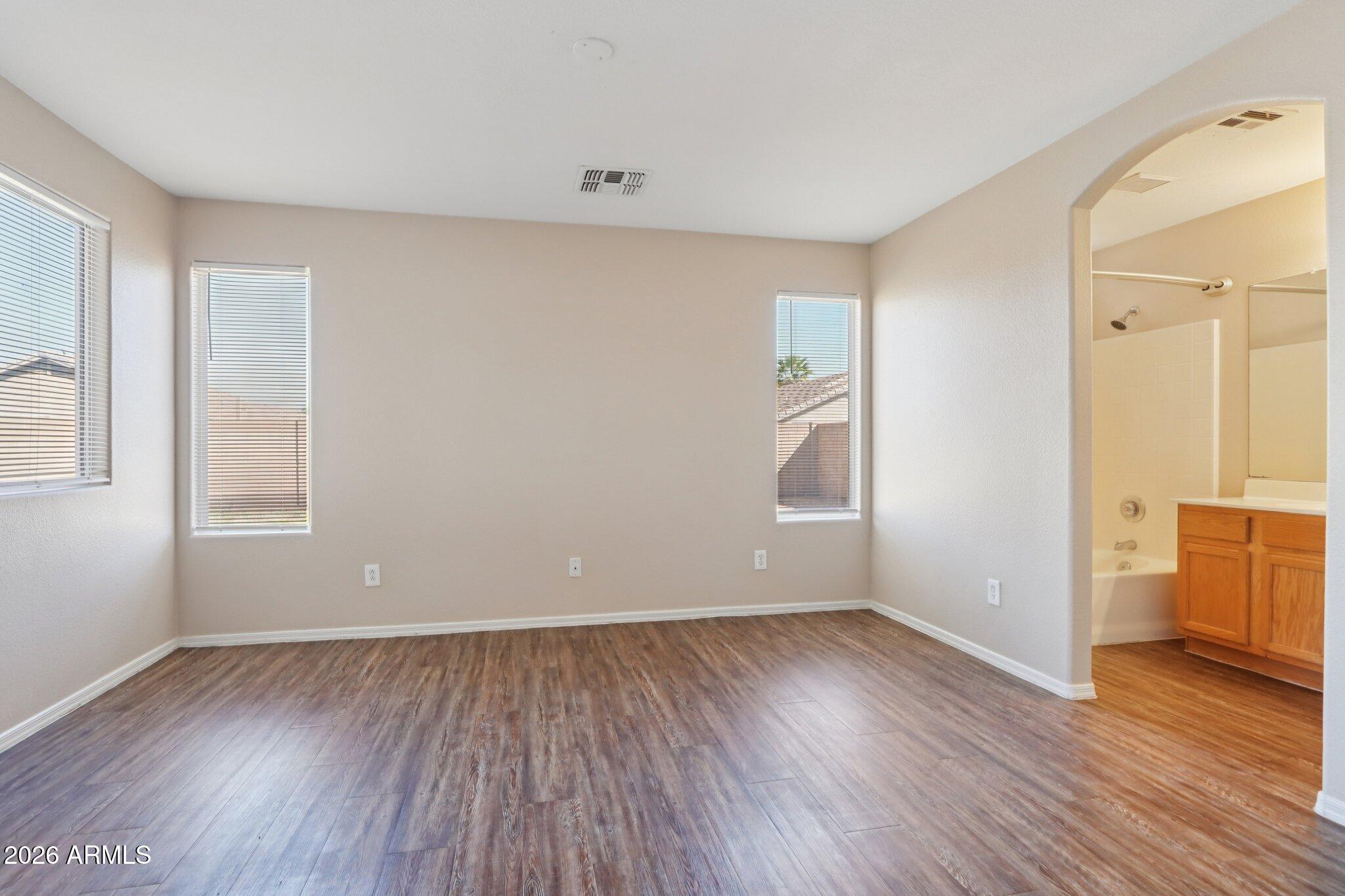 3326 West Shumway Farm Road Phoenix, AZ 85041 - Photo 25 of 30 an empty room with wooden floor and windows