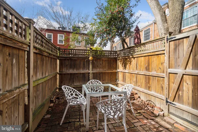 a view of a balcony with table and chairs and wooden fence