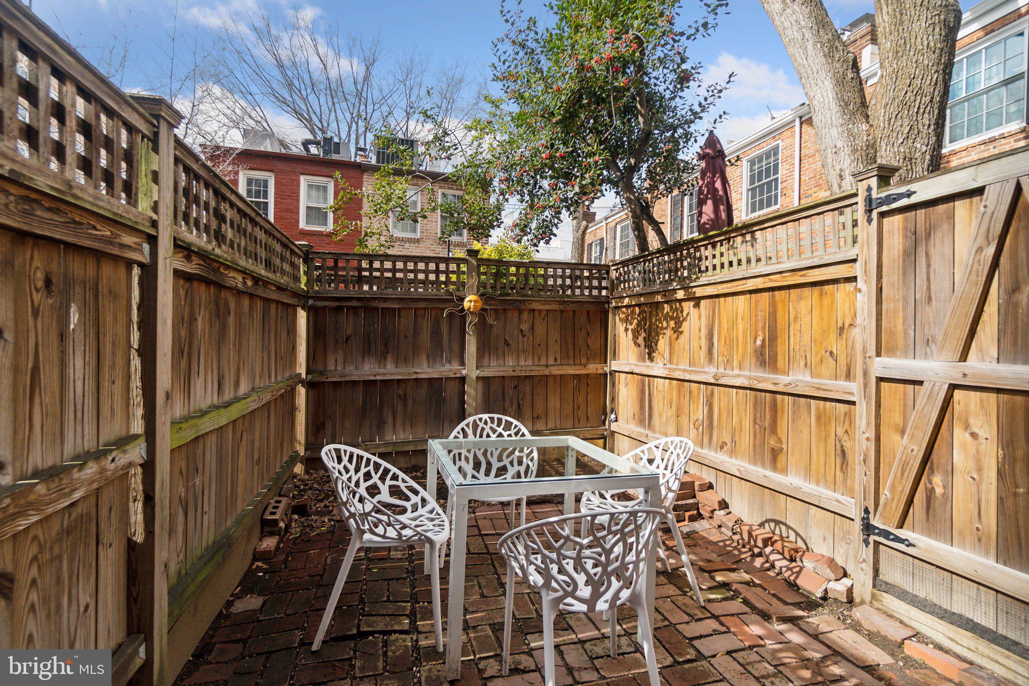 19 Snows Court Northwest Washington, DC 20037 - Photo 3 of 21 a view of a balcony with table and chairs and wooden fence