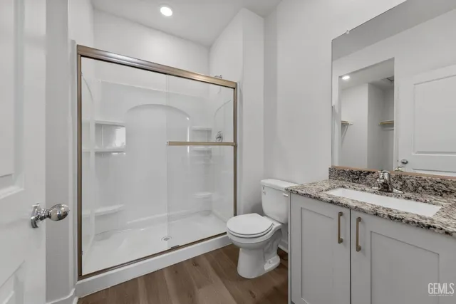 a bathroom with a granite countertop sink toilet and shower
