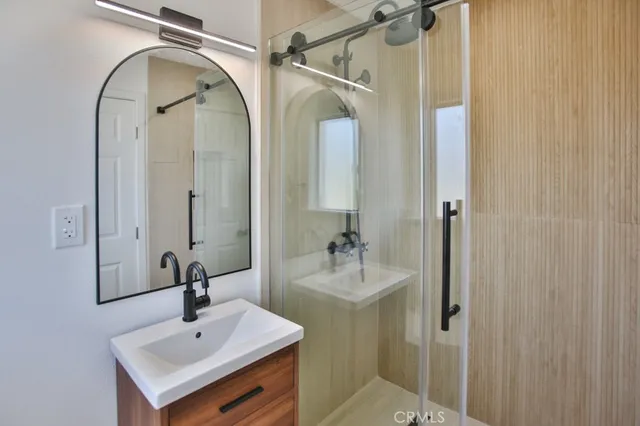 a bathroom with a sink a mirror a toilet and shower