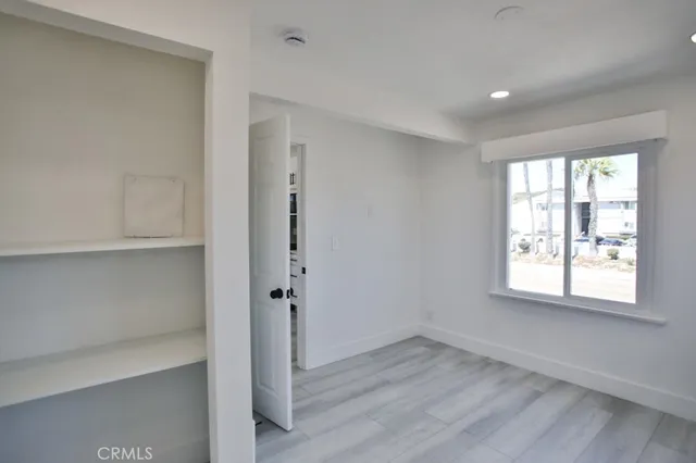 an empty room with wooden floor and window
