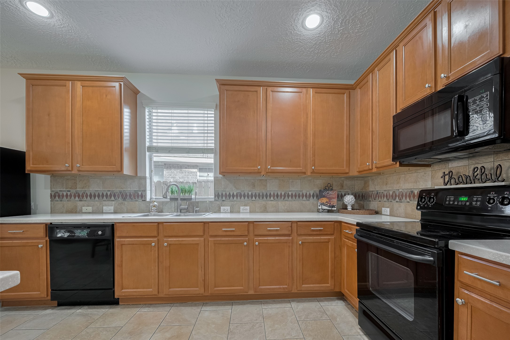 31214 Windcrest Park Lane Spring, TX 77386 - Photo 16 of 45 a kitchen with stainless steel appliances granite countertop a stove a sink dishwasher and a microwave oven with cabinets