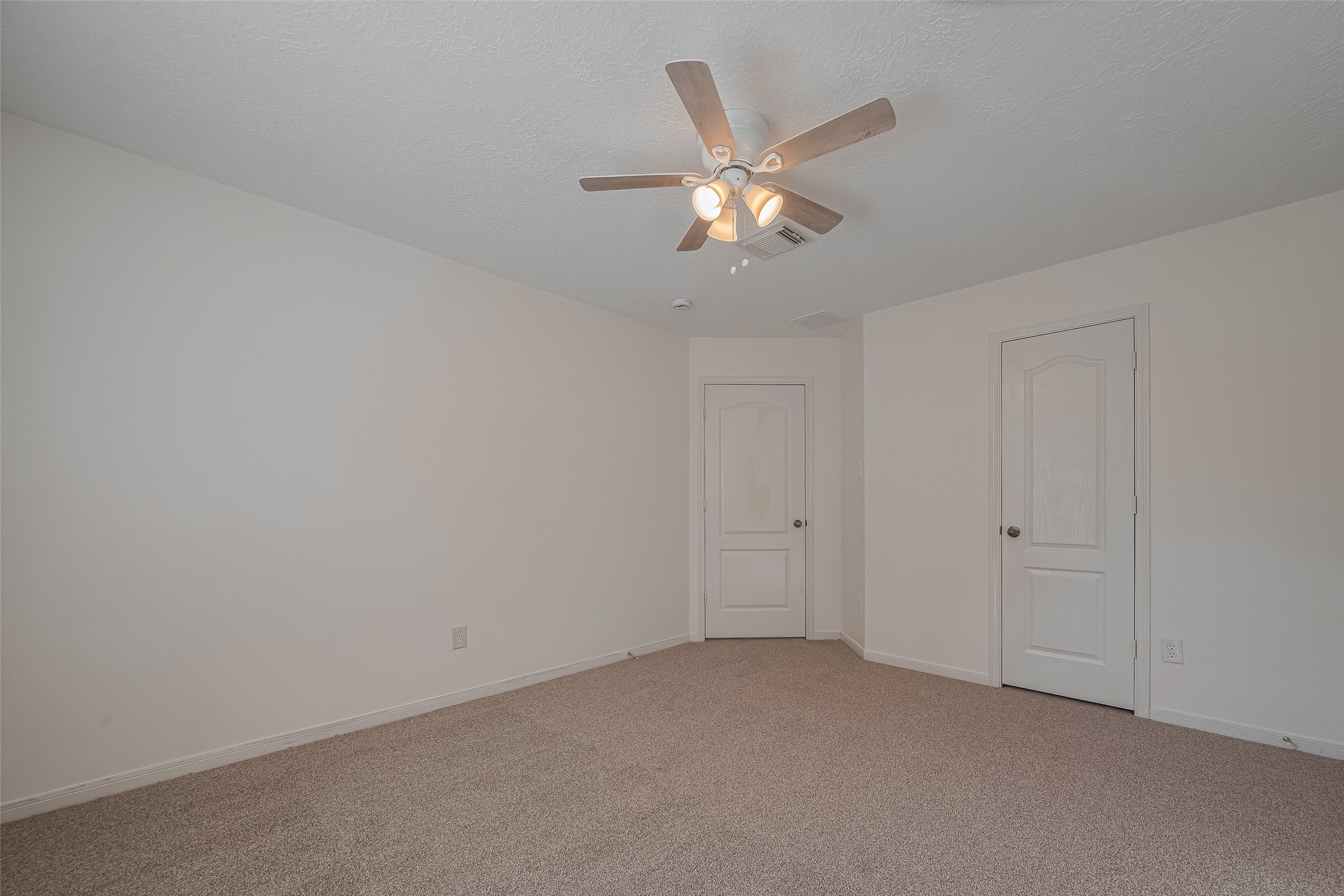 31214 Windcrest Park Lane Spring, TX 77386 - Photo 28 of 45 an empty room with a chandelier fan and kitchen view