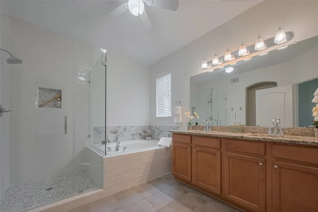 a bathroom with a granite countertop sink a large mirror and a bathtub