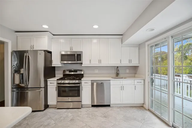 a kitchen with kitchen island a sink stainless steel appliances and cabinets