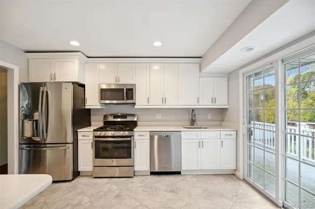 a kitchen with stainless steel appliances a refrigerator stove and microwave
