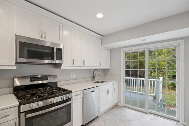 a kitchen with granite countertop a sink stove top oven and cabinets
