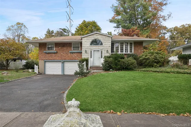 a front view of a house with a garden and yard