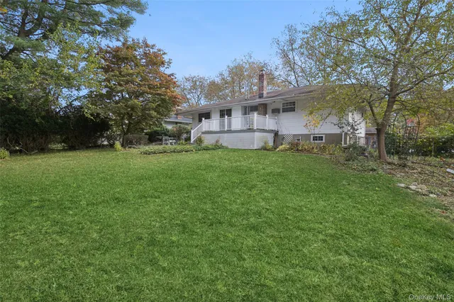 a front view of a house with a garden and trees