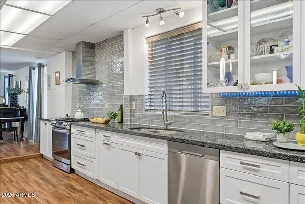 a kitchen with stainless steel appliances white cabinets and a window