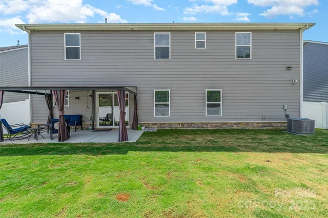 a swimming pool with outdoor seating and yard