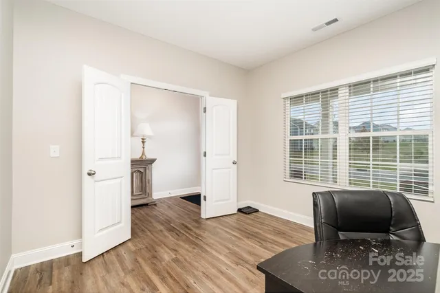 a living room with furniture and a view of kitchen