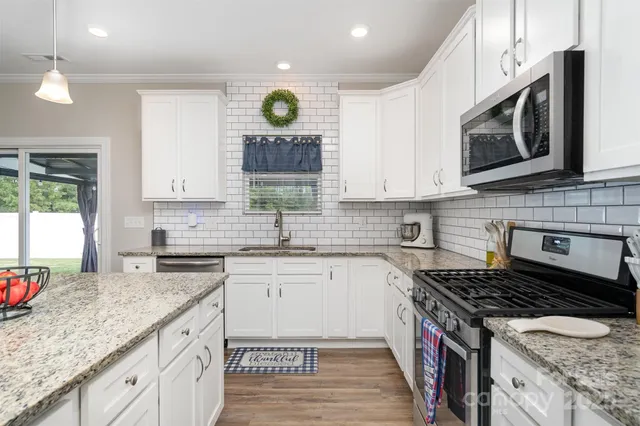 a kitchen with sink stove and wooden cabinets