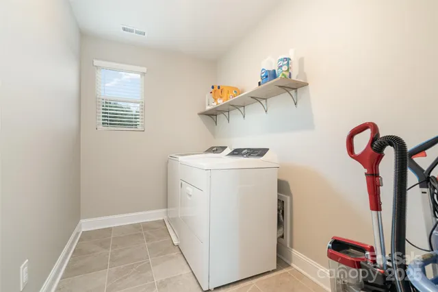a front view of a house with a yard and potted plants