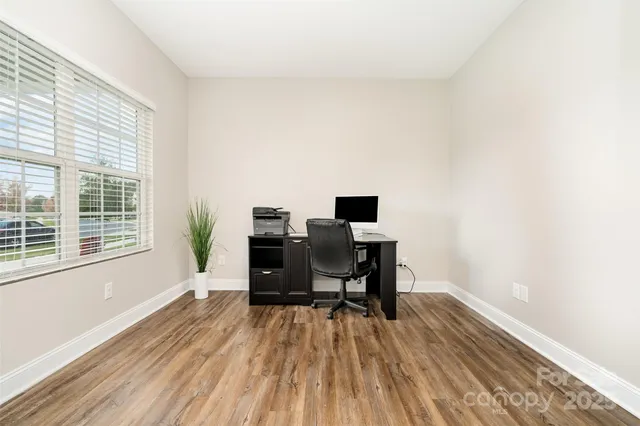 a view of a workspace with furniture and a window