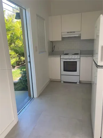 a kitchen with white cabinets and white appliances