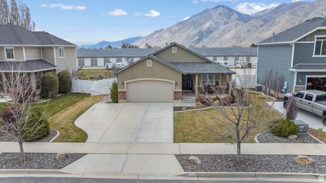 1896 West 800 North Mapleton, UT 84663 - Photo 54 of 55 View of front facade featuring covered porch, stucco siding, concrete driveway, an attached garage, and a mountain view