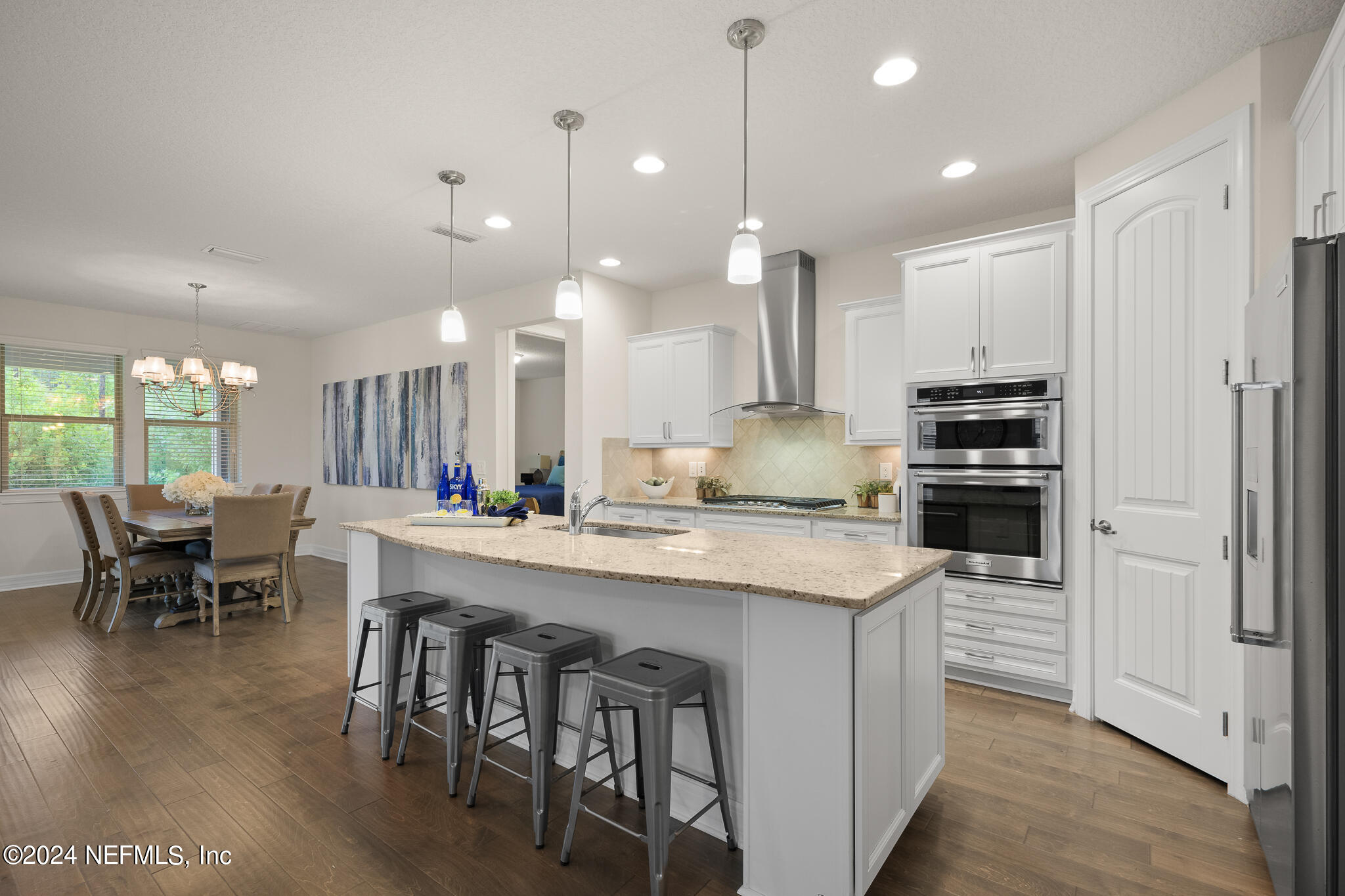 91 Broomsedge Circle St. Augustine, FL 32095 - Photo 11 of 45 a kitchen with kitchen island a dining table chairs and wooden floor