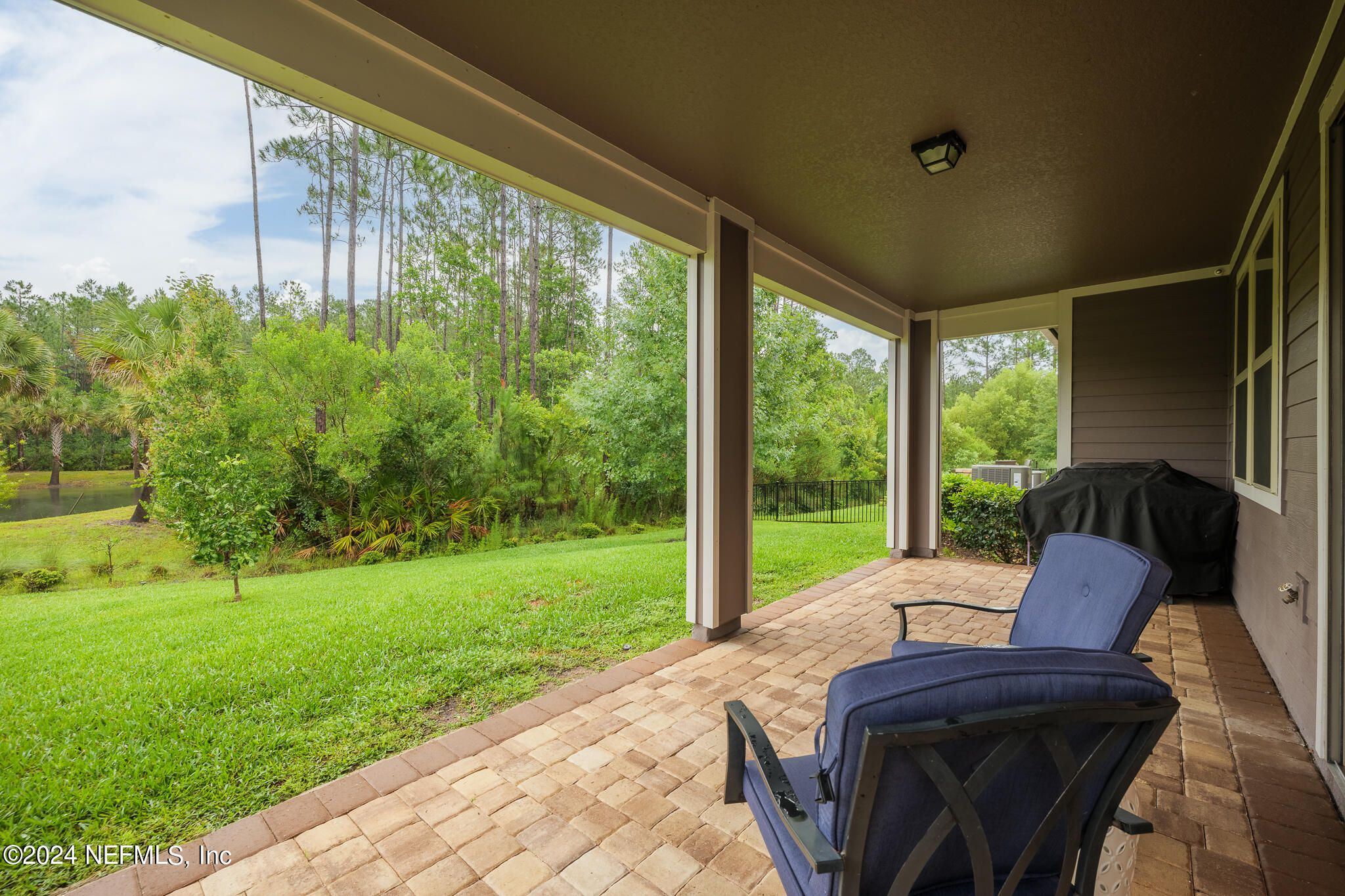 91 Broomsedge Circle St. Augustine, FL 32095 - Photo 35 of 45 a view of a patio with lawn chairs floor to ceiling window and garden