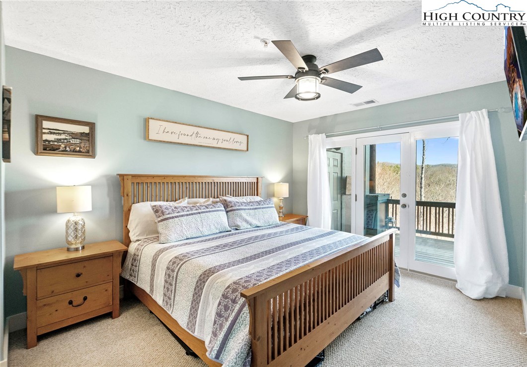 446 Peaceful Haven Drive, Unit 832 Boone, NC 28607 - Photo 17 of 38 a bedroom with a bed and a chandelier