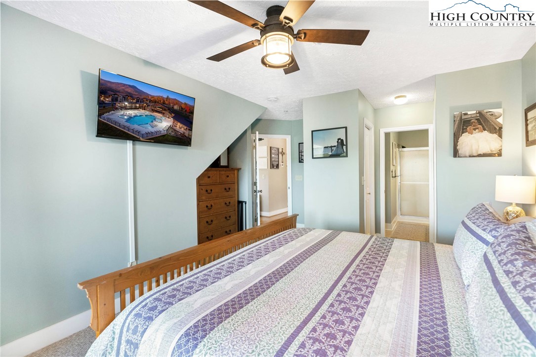 446 Peaceful Haven Drive, Unit 832 Boone, NC 28607 - Photo 19 of 38 a bedroom with a bed and a chandelier