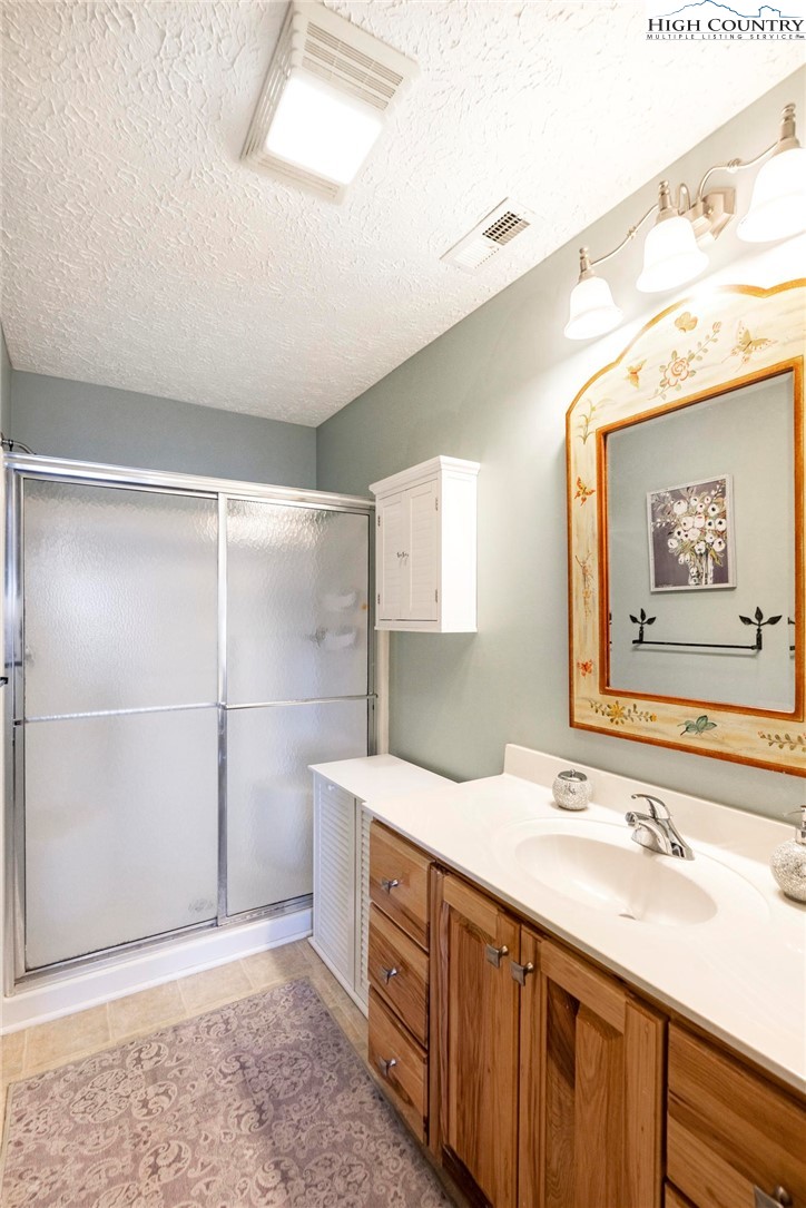 446 Peaceful Haven Drive, Unit 832 Boone, NC 28607 - Photo 21 of 38 a bathroom with a double vanity sink and a mirror
