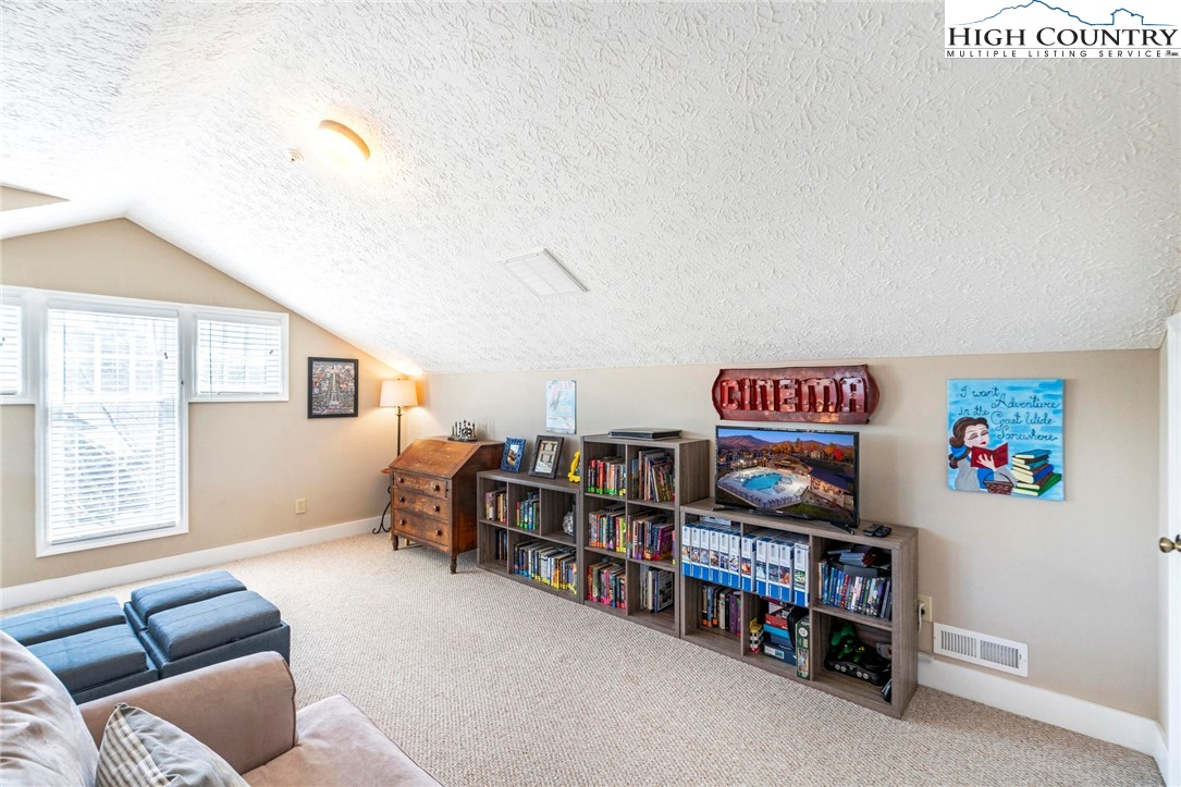 446 Peaceful Haven Drive, Unit 832 Boone, NC 28607 - Photo 27 of 38 a living room with furniture and a book shelf